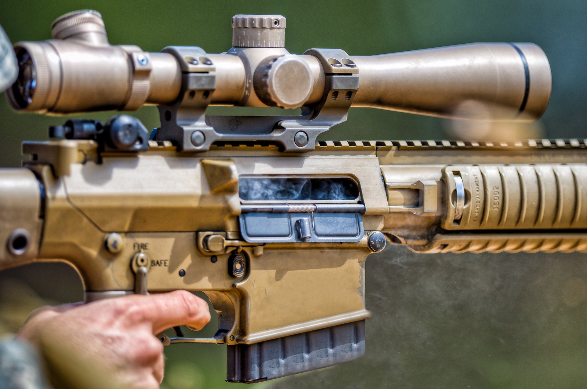 Close-up of a man-made assault rifle with a scope, featuring detailed mechanics. This high-definition image serves as a striking PC desktop wallpaper and background.
