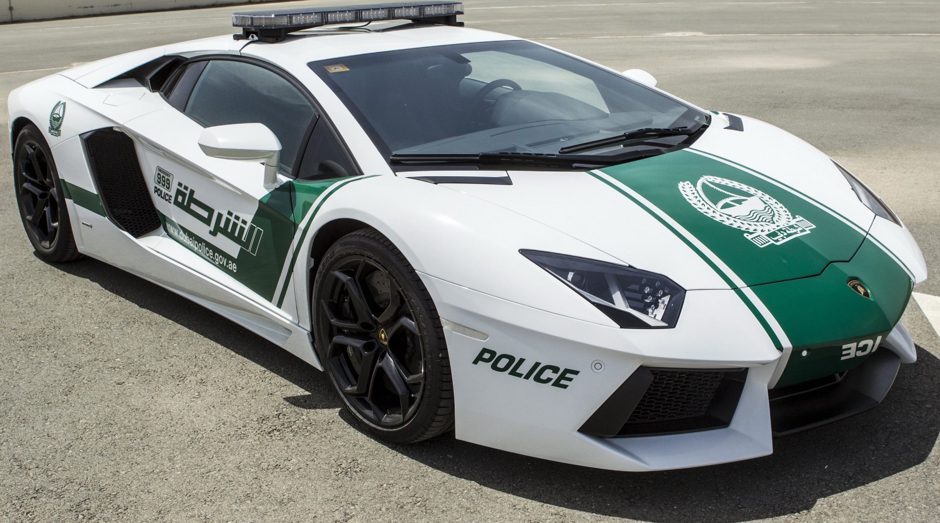 A striking Lamborghini Aventador, customized for police use, showcasing its sleek design and distinctive white and green livery against a textured background.