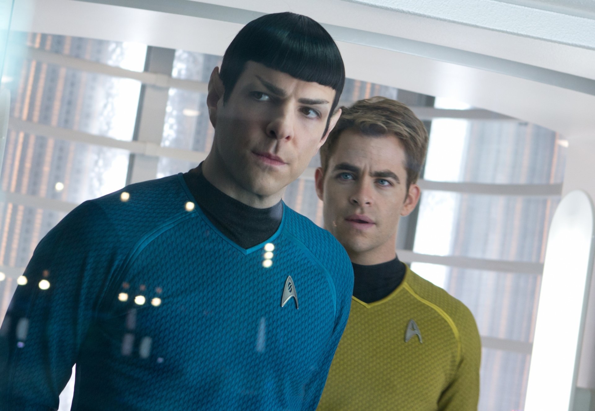 A scene from Star Trek Into Darkness, featuring characters in blue and gold Starfleet uniforms, set against a futuristic background. HD desktop wallpaper for fans of the movie.