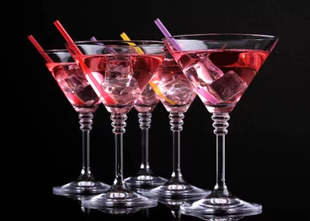 A collection of colorful cocktails with ice, each garnished with a vibrant straw, set against a sleek black background. This 4K Ultra HD wallpaper is visually striking and inviting.