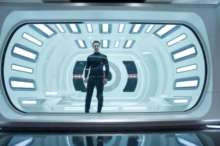 HD PC desktop wallpaper featuring a scene from the movie Star Trek Into Darkness, showing a character standing inside a futuristic, brightly lit corridor.