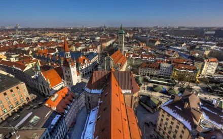 HD PC desktop wallpaper and background: aerial view of Munich's man-made cityscape — red roofs, church towers and river beneath a clear blue sky.