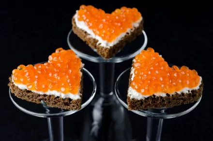 HD desktop wallpaper featuring heart-shaped appetizers topped with vibrant orange caviar on a dark background, highlighting food and caviar themes.