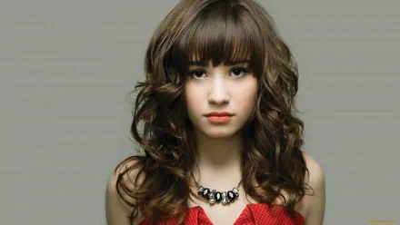 A close-up portrait of Demi Lovato, featuring her signature wavy hair and striking makeup. This HD image serves as a vibrant PC desktop wallpaper and background.