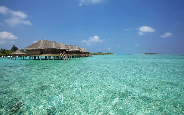 HD tropical photography of clear turquoise waters with overwater bungalows under a blue sky, captured as a PC desktop wallpaper and background.