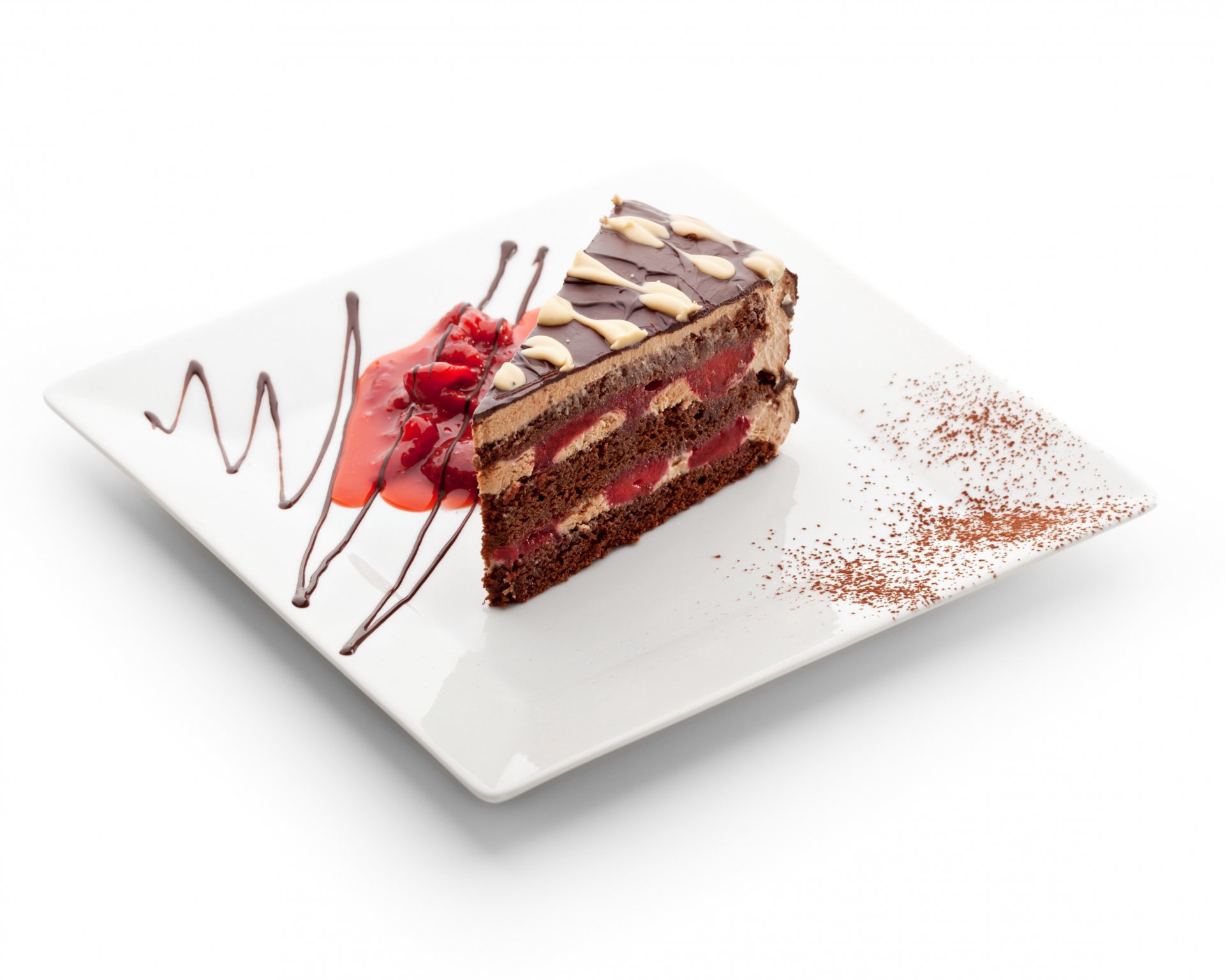 A slice of layered chocolate and berry cake garnished with raspberry sauce and cocoa powder on a white plate, captured in stunning 4K Ultra HD for PC desktop background.