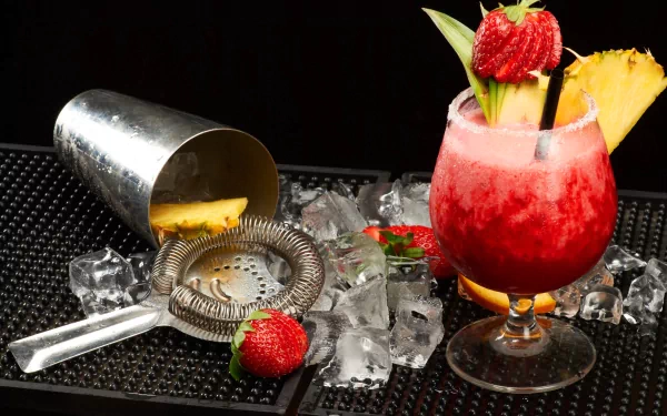 A vibrant strawberry and pineapple cocktail with fresh fruit garnishes, surrounded by ice and bartending tools, showcased in stunning 4K Ultra HD for a PC desktop wallpaper.