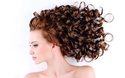 HD desktop wallpaper of a woman with long, voluminous curly hair spread out against a white background.