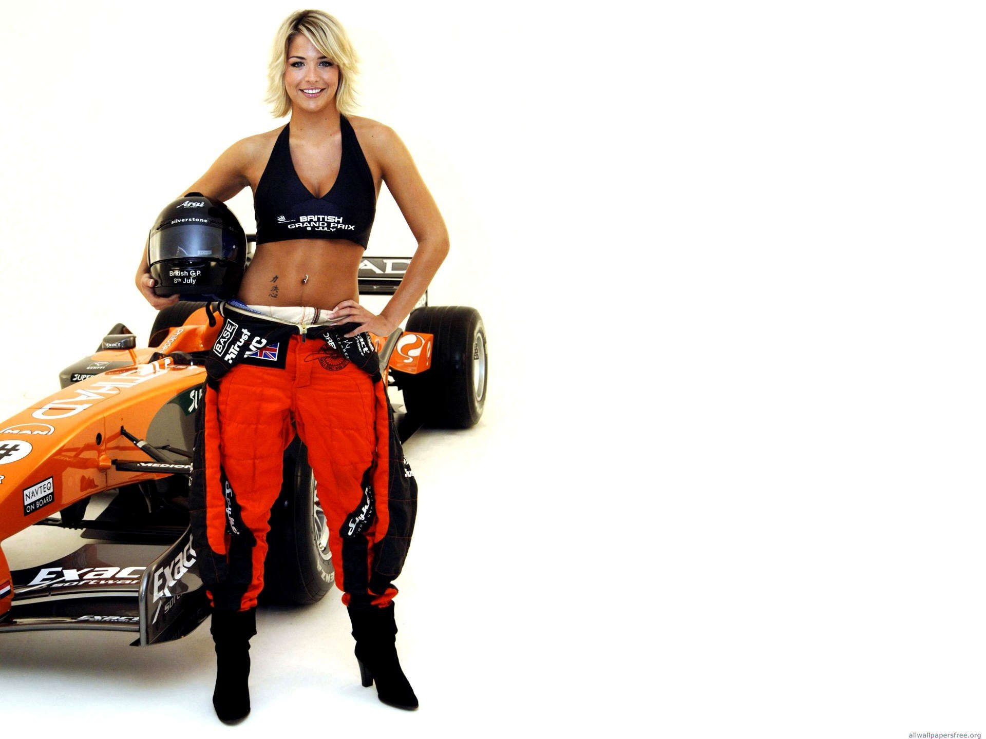 HD PC desktop wallpaper of a smiling woman in racing gear holding a helmet beside an orange formula car on a white background.