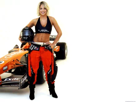 HD PC desktop wallpaper of a smiling woman in racing gear holding a helmet beside an orange formula car on a white background.