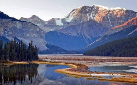 Sunrise over Mount Kitchener and a winding river in Jasper National Park, Alberta, Canada, showcasing serene mountain and nature views.