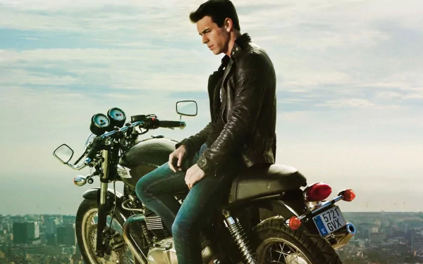 A striking HD wallpaper featuring Mario Casas sitting on a motorcycle, exuding a cool and confident vibe against a scenic background.