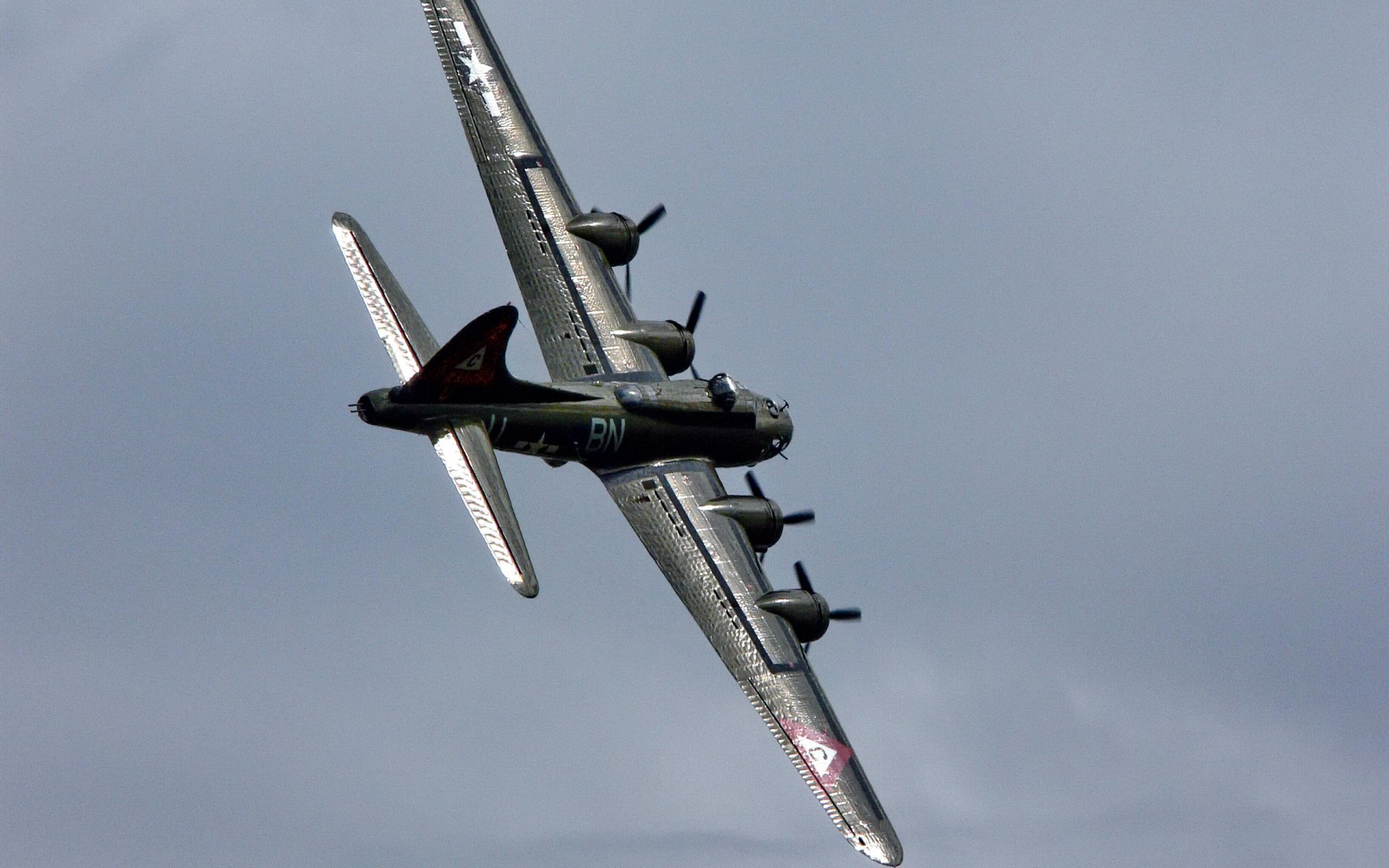 HD desktop wallpaper featuring a Boeing B-17 Flying Fortress military aircraft soaring through a cloudy sky.