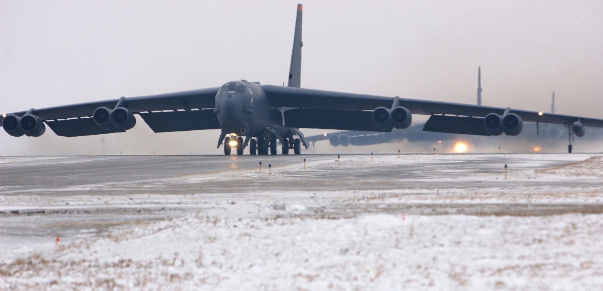 A Boeing B-52 Stratofortress takes off on a snowy runway, showcasing its imposing design. This HD image serves as a striking desktop wallpaper and background for military enthusiasts.