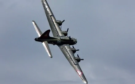 HD desktop wallpaper featuring a Boeing B-17 Flying Fortress military aircraft soaring through a cloudy sky.