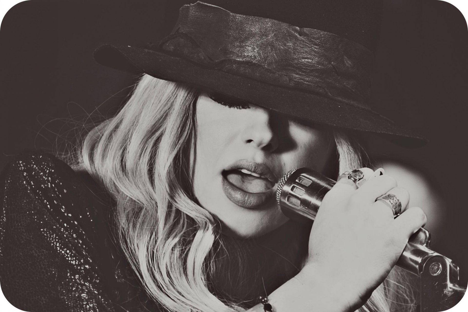 Black and white HD desktop wallpaper featuring Orianthi singing into a microphone, capturing her music energy and style.