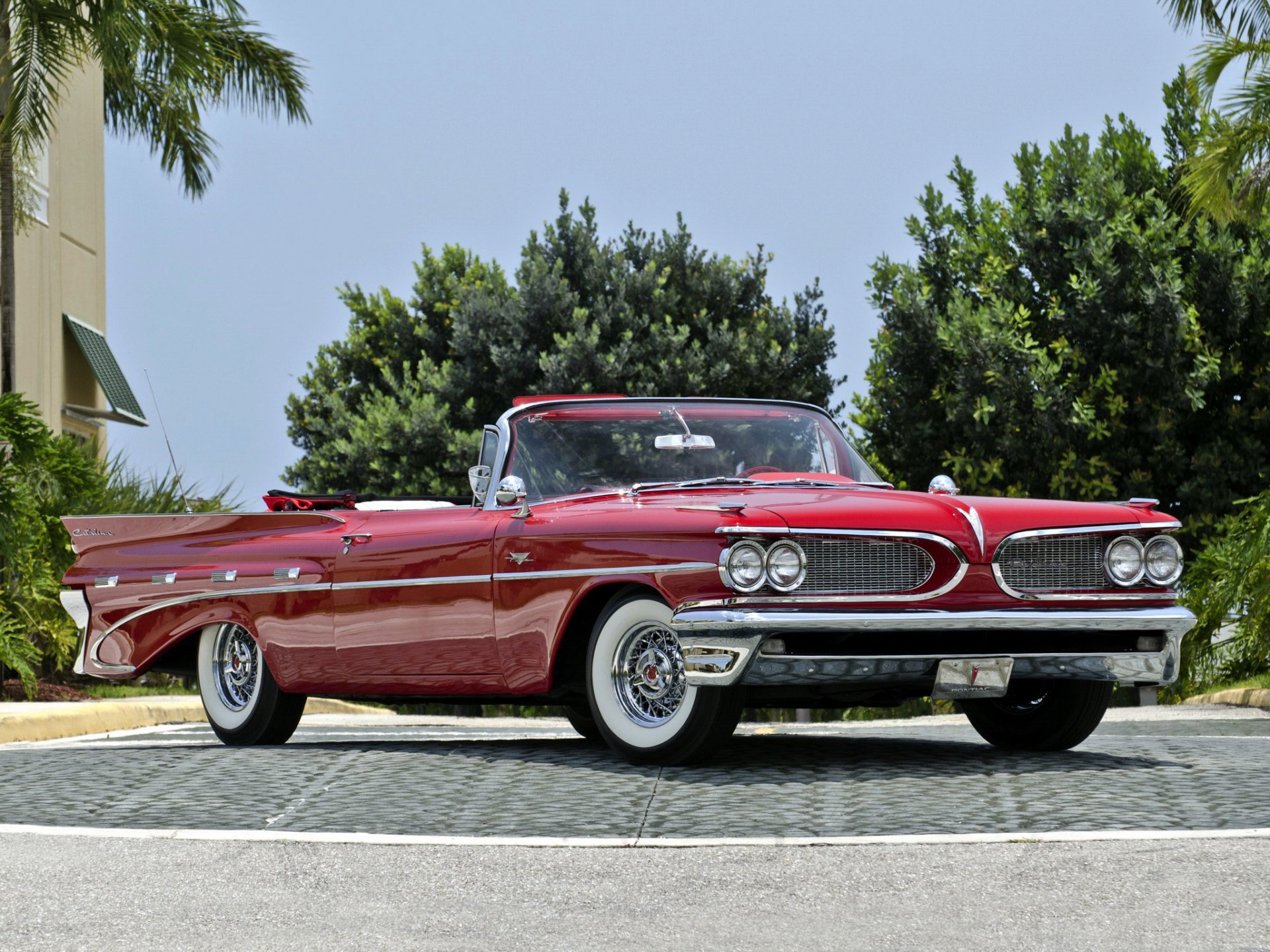 HD PC desktop wallpaper and background: red classic Pontiac convertible vehicle parked on a sunlit driveway with palm trees and a leafy green backdrop.