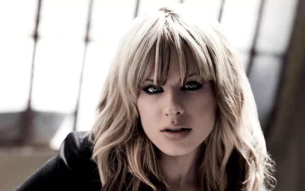 HD PC desktop wallpaper featuring a close-up portrait of Orianthi with blonde hair and intense gaze, set against a softly lit background.