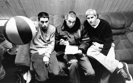 Black and white HD PC desktop wallpaper featuring the Beastie Boys sitting together in a casual indoor setting, reflecting their iconic music style.