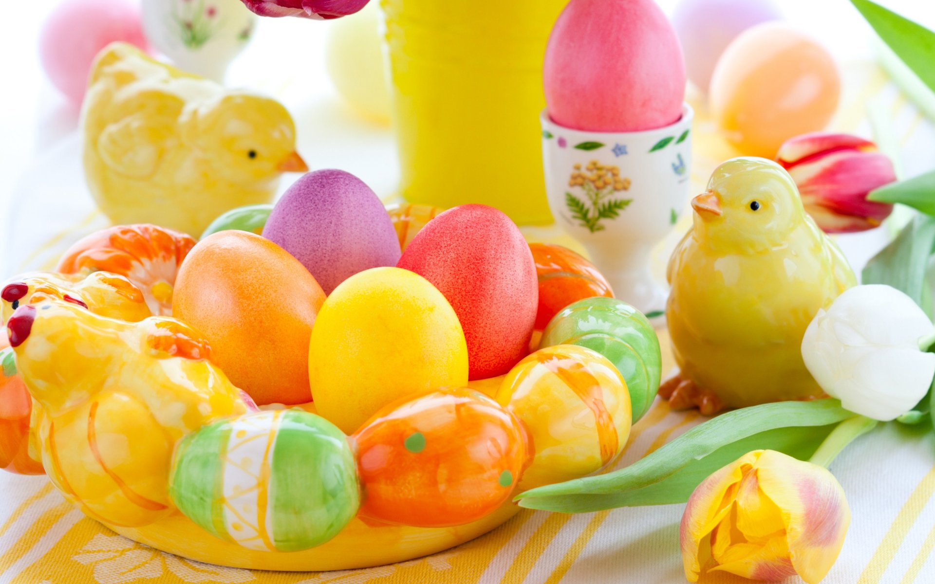 A vibrant Easter-themed desktop wallpaper featuring colorful eggs, cheerful chicks, and tulips, creating a festive and joyful holiday atmosphere.