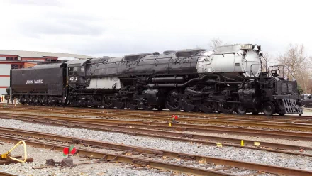 HD PC desktop wallpaper featuring a classic steam locomotive train on railway tracks under a cloudy sky.
