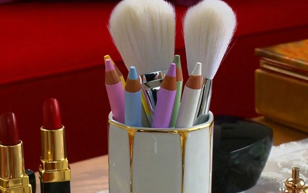 A stylish arrangement of makeup brushes and colorful pencils in a chic container, set against a vibrant background. This HD photograph serves as a stunning desktop wallpaper and background.