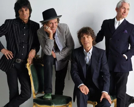 HD desktop wallpaper featuring The Rolling Stones band members dressed in stylish suits against a light background, capturing their iconic music legacy.