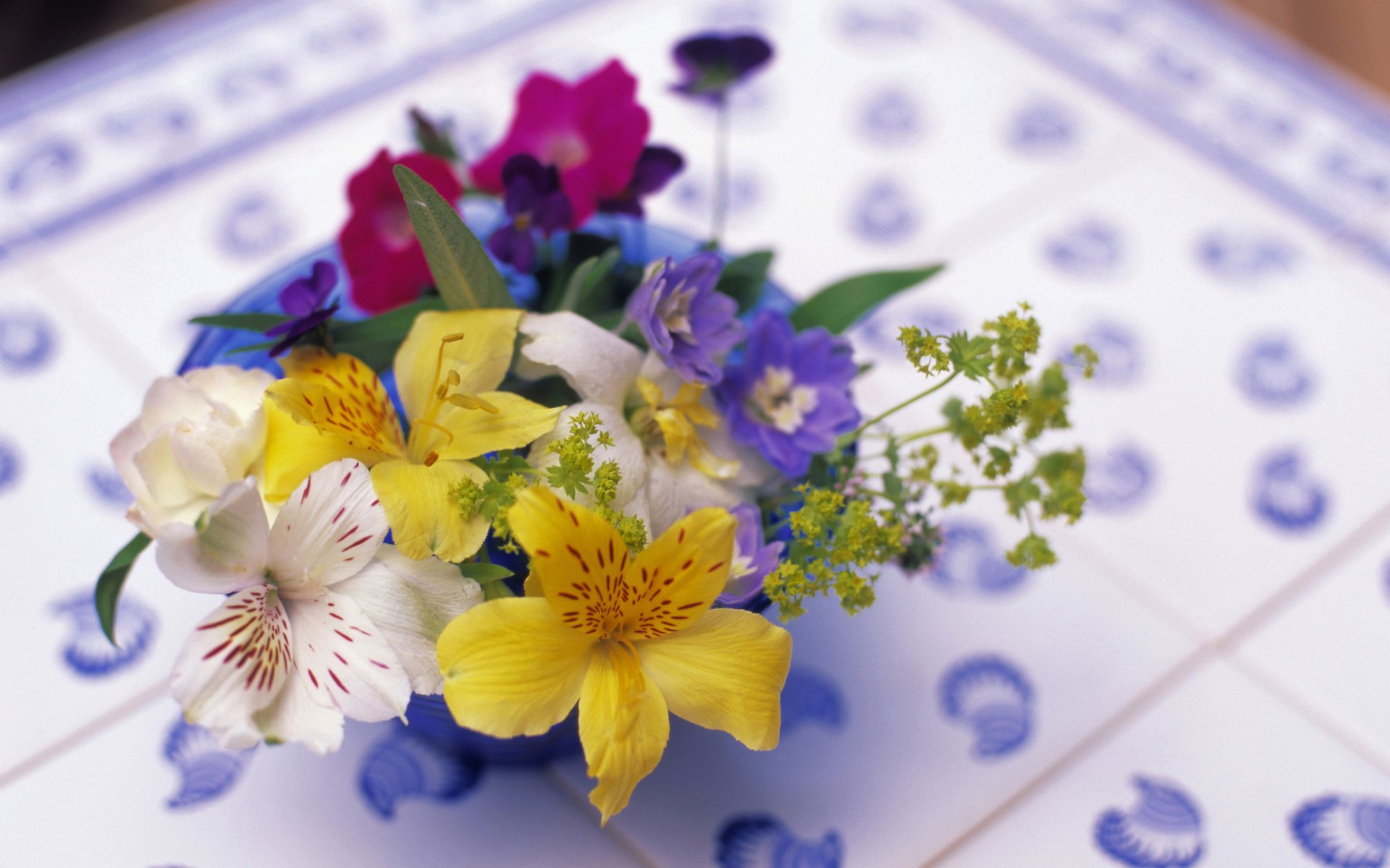 A vibrant bouquet of assorted flowers arranged beautifully on a tiled surface, showcased as a high-definition PC desktop wallpaper and background.