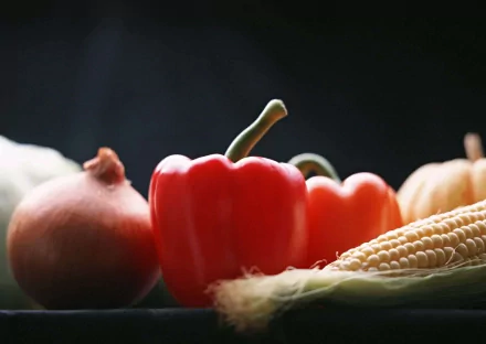 HD PC desktop wallpaper featuring a close-up of fresh vegetables, including a red bell pepper, onion, and corn, against a dark background.