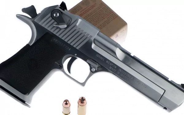 A high-definition desktop wallpaper featuring a Desert Eagle handgun alongside two bullets, showcasing the intricate details of this iconic firearm.