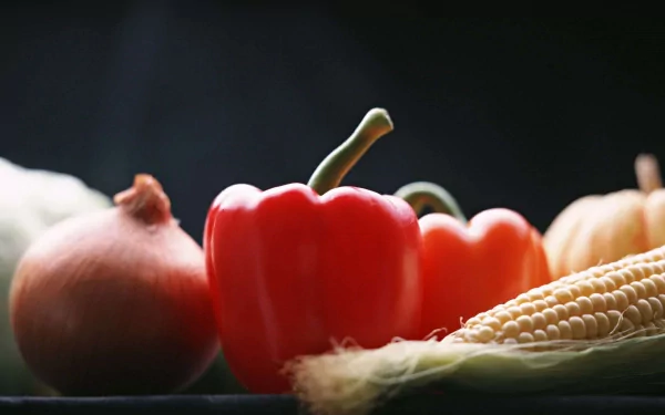 HD PC desktop wallpaper featuring a close-up of fresh vegetables, including a red bell pepper, onion, and corn, against a dark background.