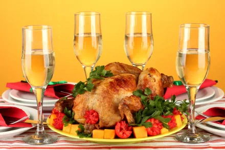 4K Ultra HD desktop wallpaper of a roasted whole chicken garnished with vegetables and surrounded by four filled wine glasses on a vibrant yellow background.