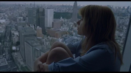 HD desktop wallpaper featuring a contemplative scene from the movie Lost In Translation, showing a woman gazing out over a sprawling cityscape at dusk.