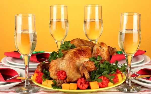 4K Ultra HD desktop wallpaper of a roasted whole chicken garnished with vegetables and surrounded by four filled wine glasses on a vibrant yellow background.