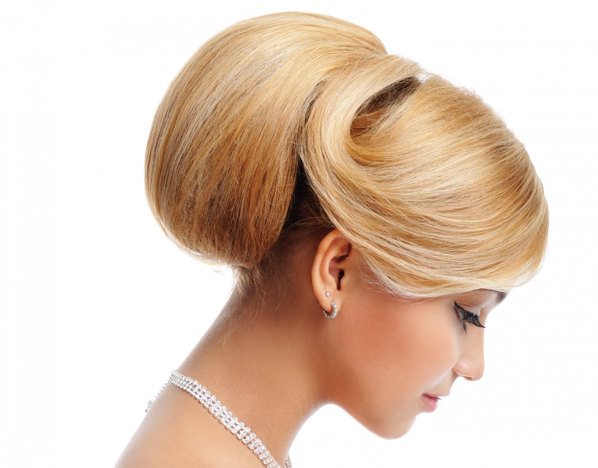 A woman with elegant, styled blonde hair is captured in profile, showcasing a sophisticated updo against a clean, white background. This makes for a striking HD desktop wallpaper.