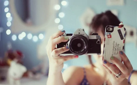 Close-up of a person holding a man-made camera and phone, captured in high definition, designed as a PC desktop wallpaper and background.