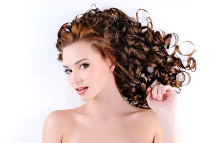 A woman with beautiful, voluminous curly hair poses gracefully against a white background, making this 4K Ultra HD image an eye-catching desktop wallpaper.