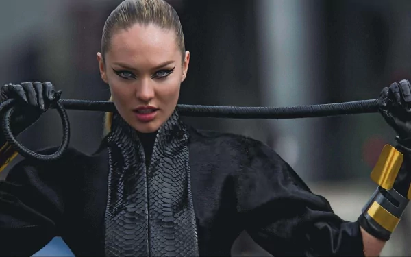 A striking HD desktop wallpaper featuring a woman in a sleek black outfit, holding a whip with fierce expression, showcasing bold fashion and attitude.