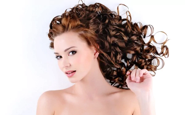 A woman with beautiful, voluminous curly hair poses gracefully against a white background, making this 4K Ultra HD image an eye-catching desktop wallpaper.