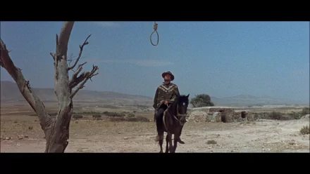 HD desktop wallpaper featuring Clint Eastwood on horseback in a desert scene from the movie A Fistful of Dollars, with a noose hanging from a barren tree.