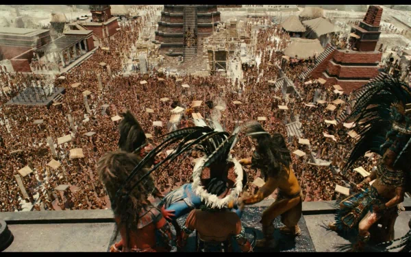 HD PC desktop wallpaper from the movie Apocalypto: rulers in feathered headdresses gaze over a packed Mesoamerican ceremonial plaza.