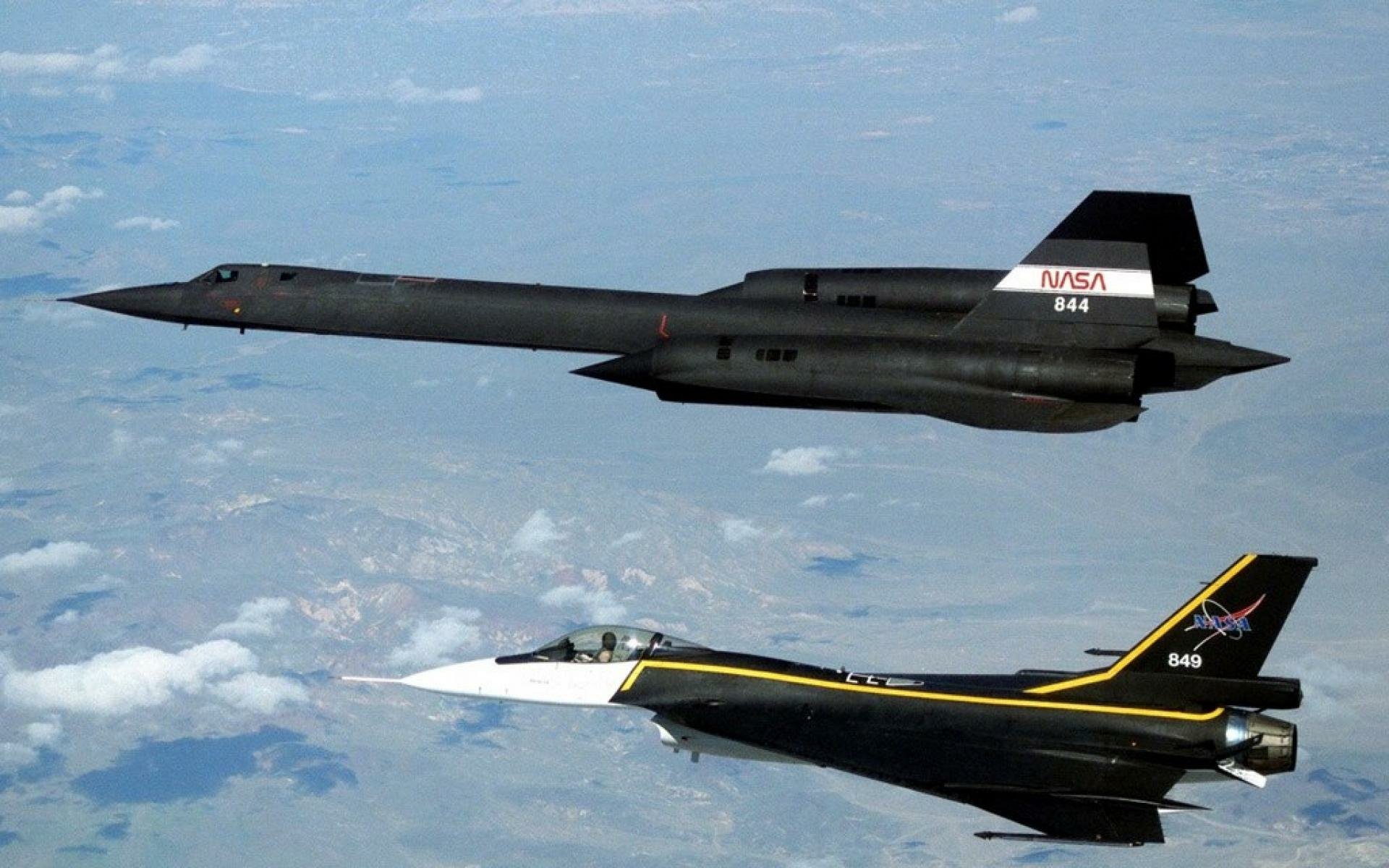 HD desktop wallpaper featuring two military aircraft, including the Lockheed SR-71 Blackbird, soaring above the clouds.