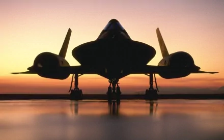 Silhouetted Lockheed SR-71 Blackbird on a runway at sunset, captured in a high-definition military-themed desktop wallpaper.