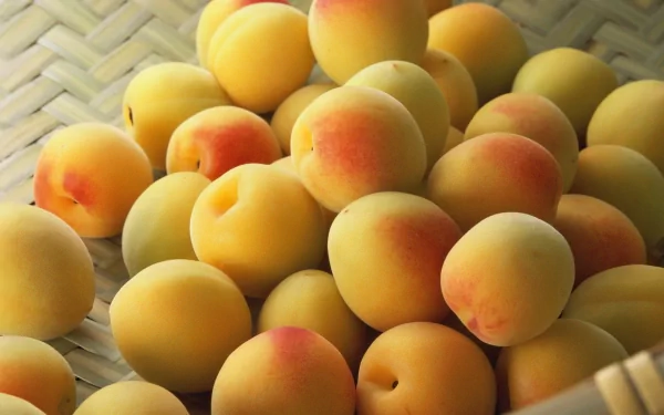 A vibrant HD desktop wallpaper featuring a close-up of fresh, ripe peaches, showcasing their smooth skin and soft, inviting colors against a textured background.