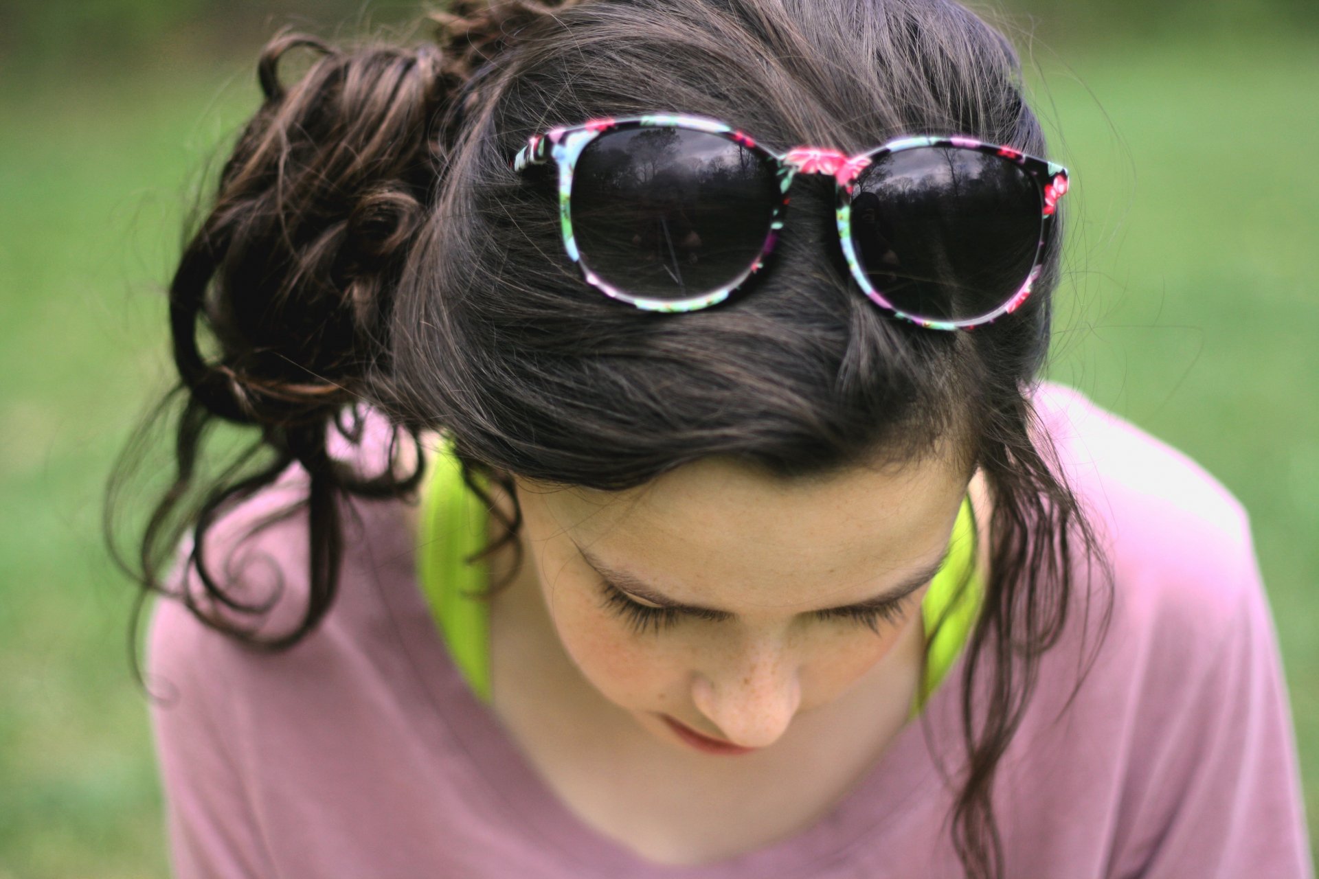 Close-up of a woman with dark hair styled in a loose updo, wearing floral sunglasses on her head, captured in a 4K Ultra HD PC desktop wallpaper background.