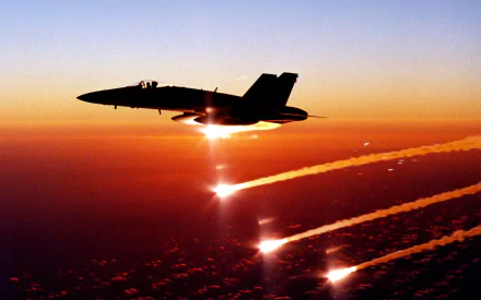 A McDonnell Douglas F/A-18 Hornet soars through a vibrant sunset, leaving streaks of vapor trails against the colorful sky, creating a striking military-themed HD desktop wallpaper.