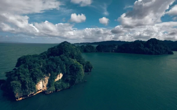 HD PC desktop wallpaper featuring a scenic nature view of lush cliffs surrounded by calm ocean waters under a partly cloudy sky.