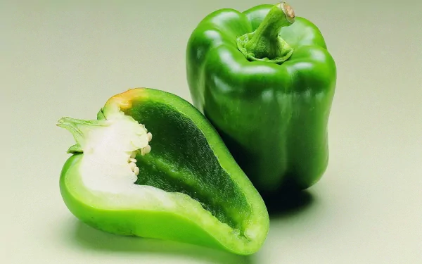 HD PC desktop wallpaper featuring a fresh whole and sliced green bell pepper against a plain light background.