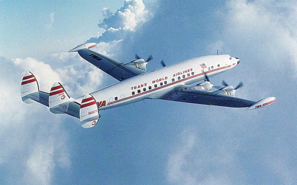 HD PC desktop wallpaper/background showing a Lockheed Constellation airliner soaring above clouds, viewed from below with four propellers and its distinctive triple-tail against a blue sky.