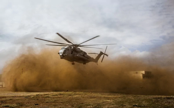 A Sikorsky CH-53E Super Stallion military helicopter kicks up dust during takeoff, captured in high definition as a dynamic PC desktop wallpaper background.